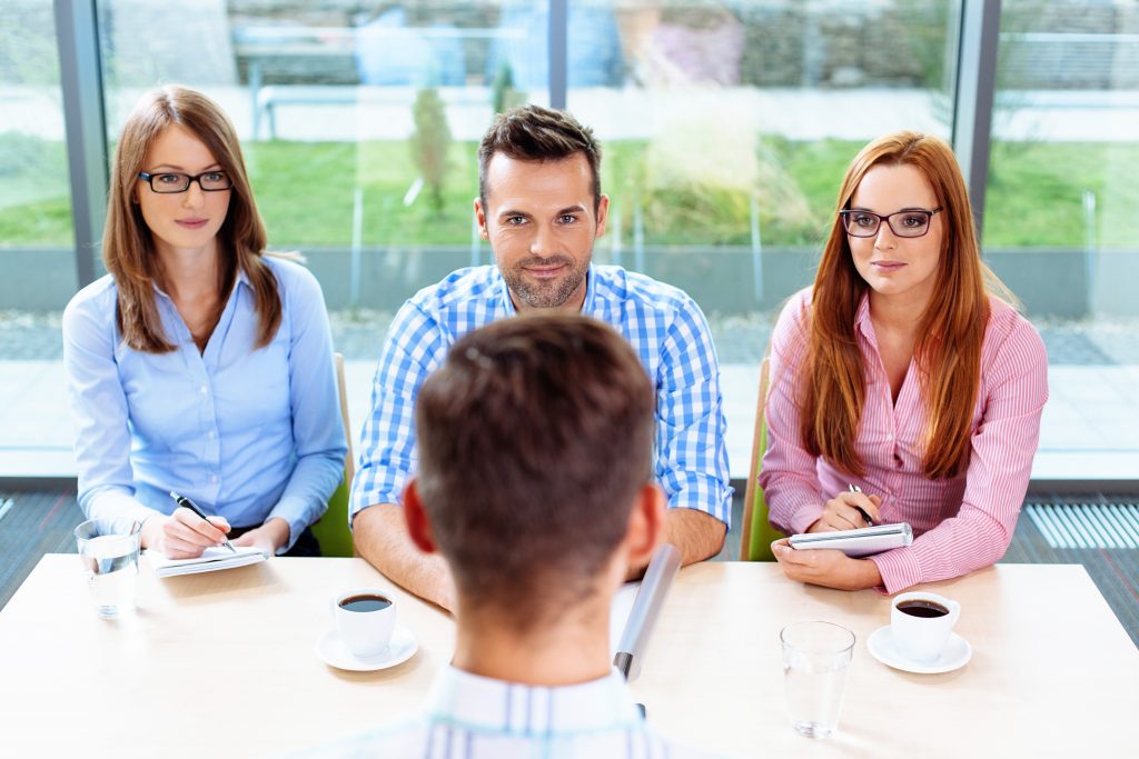 A person being interviewed by a panel of 3