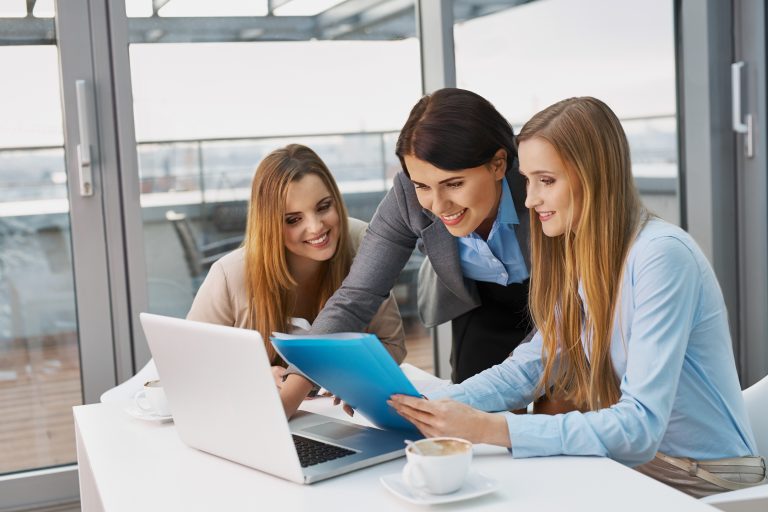 Three colleagues working together on laptop